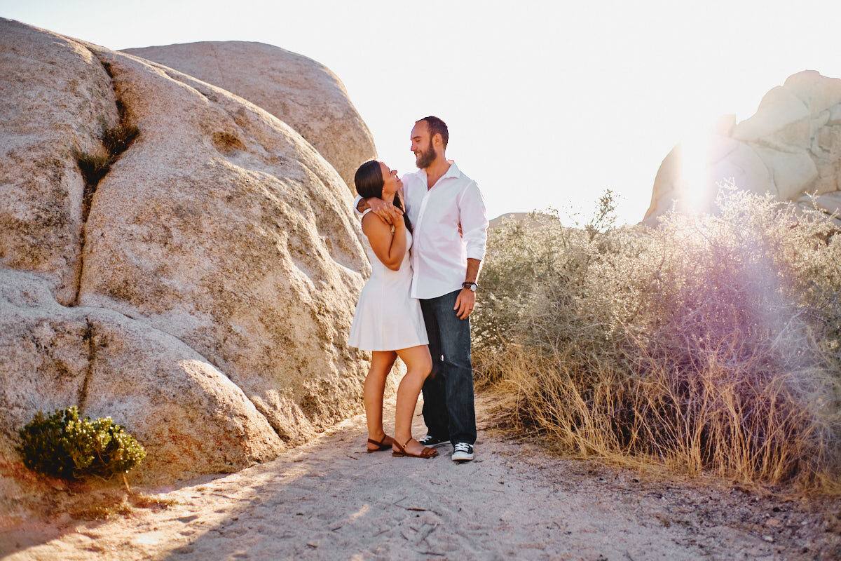 Paar vor Felsen im Gegenlicht mit Blendenfleck, Joshua Tree Nationalpark