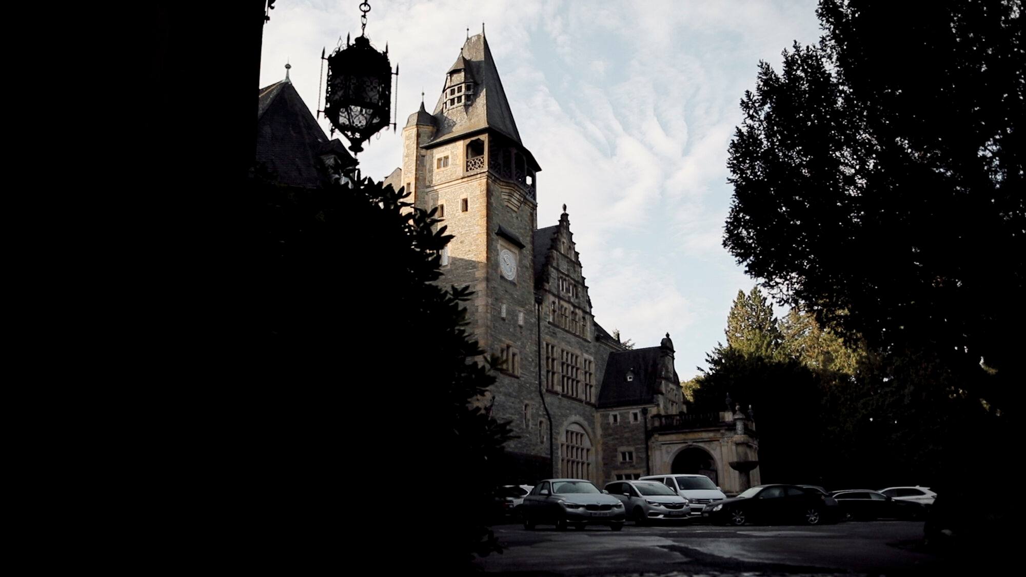 Türme des Schlosshotels Kronberg im Gegenlicht zwischen Bäumen