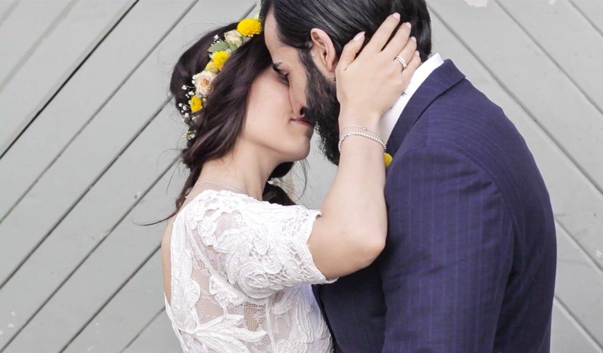 Hiscan hält Katha im Arm, Kuss vor grauer Holzwand, Hochzeit in Esslingen