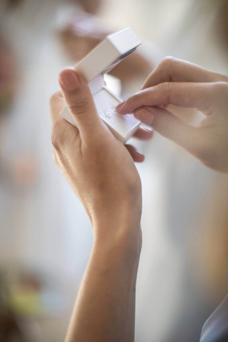 Hände öffnen eine kleine Ringschachtel, Detail Hochzeit Bolongaropalast