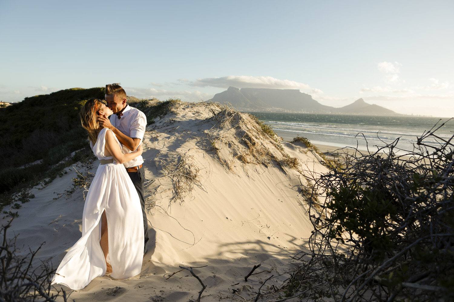Kuss in den Dünen, im Hintergrund der Tafelberg, After-Wedding-Shooting Kapstadt