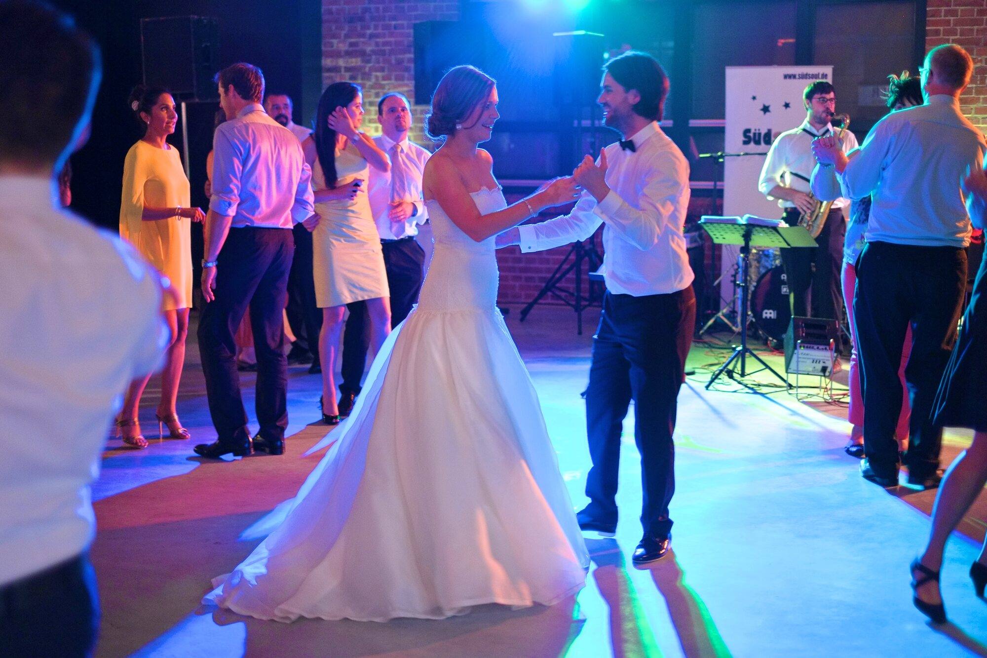 Braut und Bräutigam tanzen mit Gästen vor der Liveband im Goldbergwerk Fellbach
