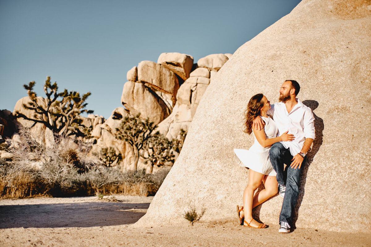 Liz und Ron an einen Granitfelsen gelehnt, dahinter Joshua Trees