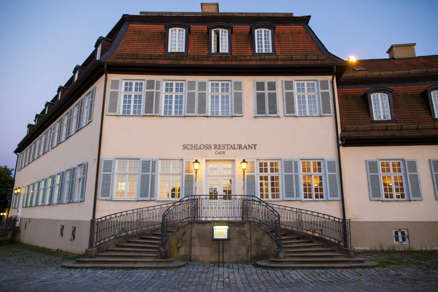 Fassade der Schlossgastronomie mit Freitreppe in der Dämmerung, Schloss Solitude
