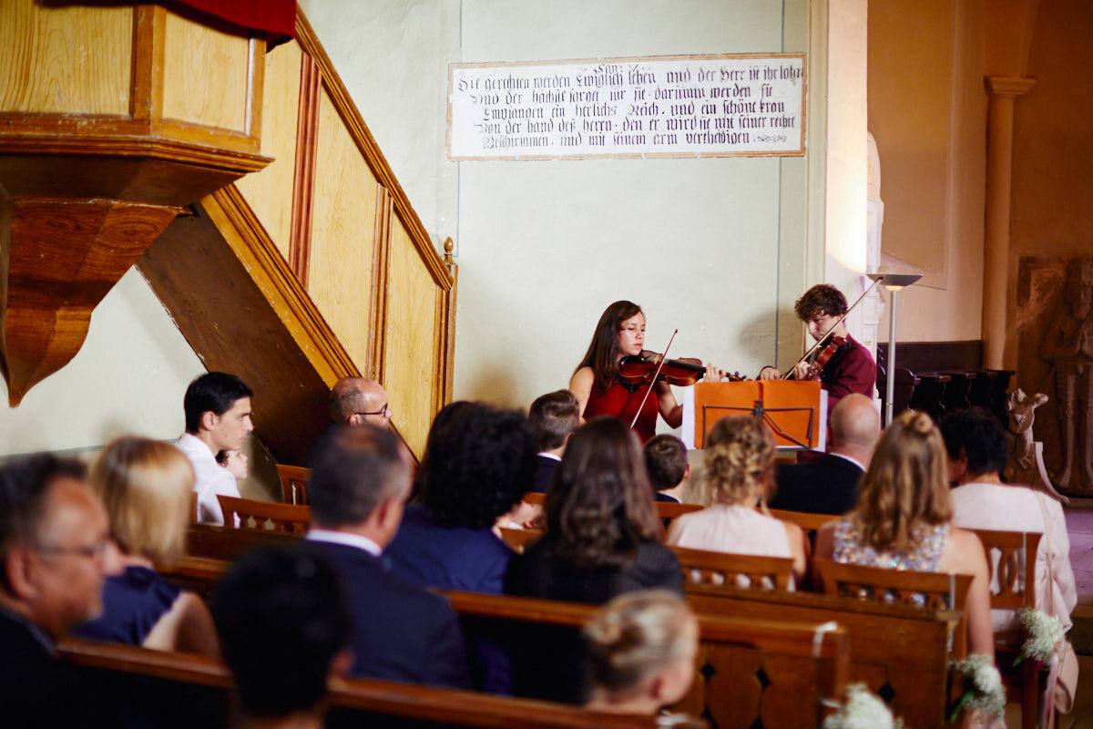 Geiger spielen in der Kapelle, Gäste in den Bänken, Schloss Neuhaus