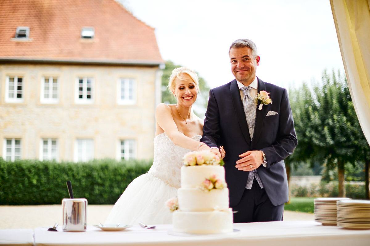 Brautpaar schneidet die Hochzeitstorte vor der Schlossfassade an, Sinsheim