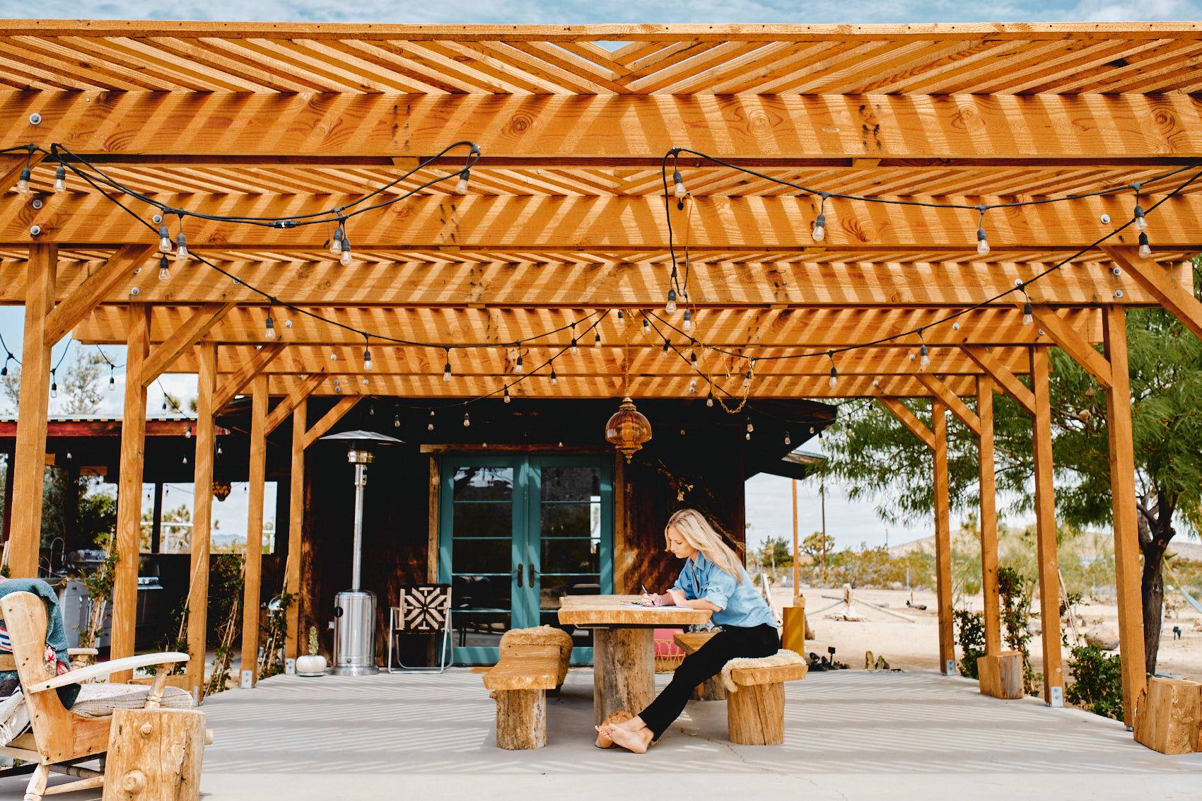 Holzpergola mit Lichterketten am Clubhaus, Airstream-Camp in der Wüste