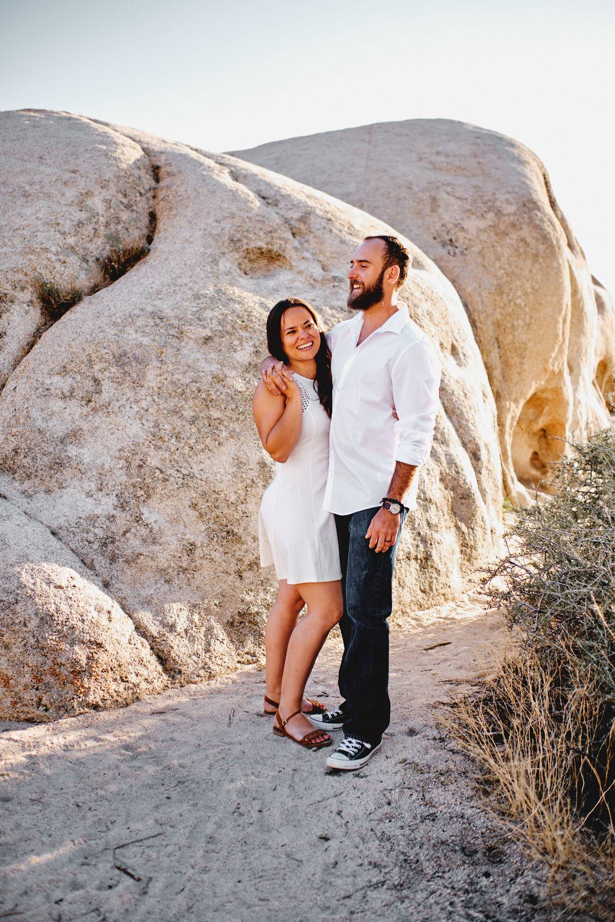 Verlobtes Paar vor hellem Granitfelsen im Joshua Tree Nationalpark