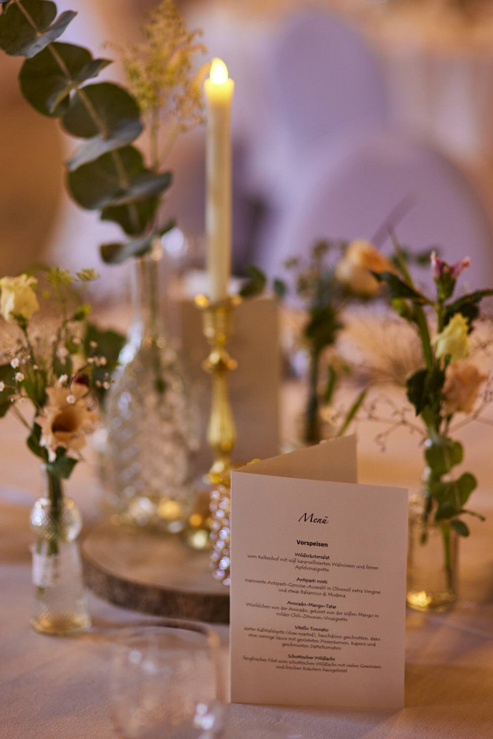 Menükarte und Kerzenlicht auf dem Hochzeitstisch.
