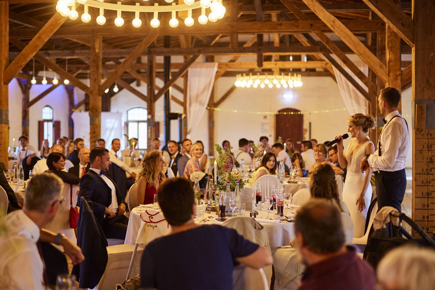 Braut hält eine Rede in der Holzhalle.