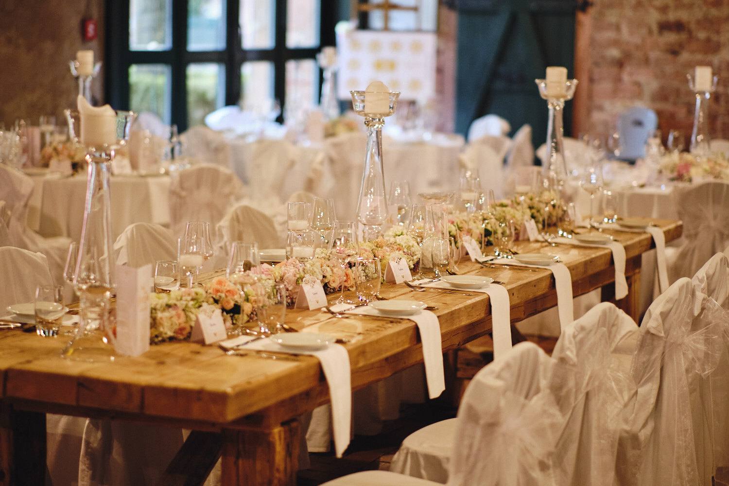 Lange Festtafel mit Kerzen und Blumen.