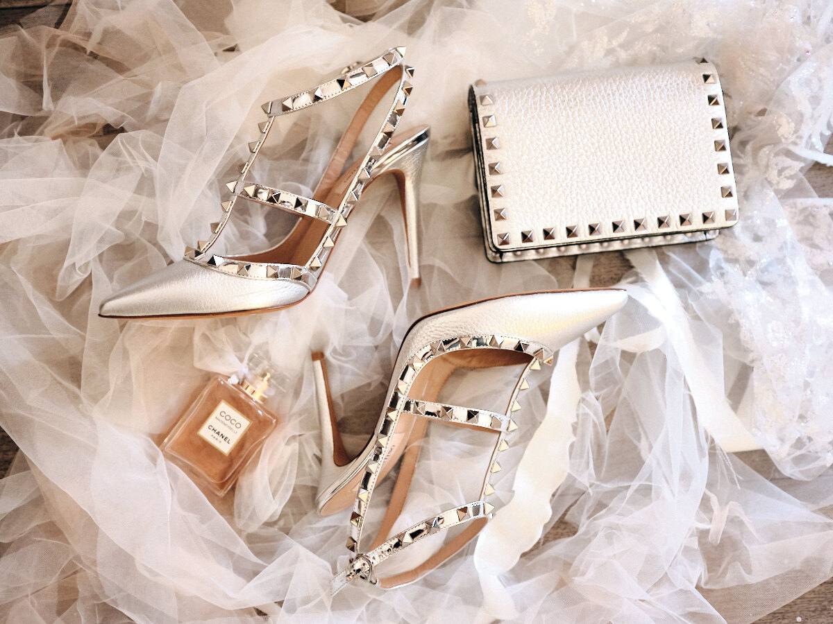 Brautschuhe, Clutch und Parfum auf Tüll