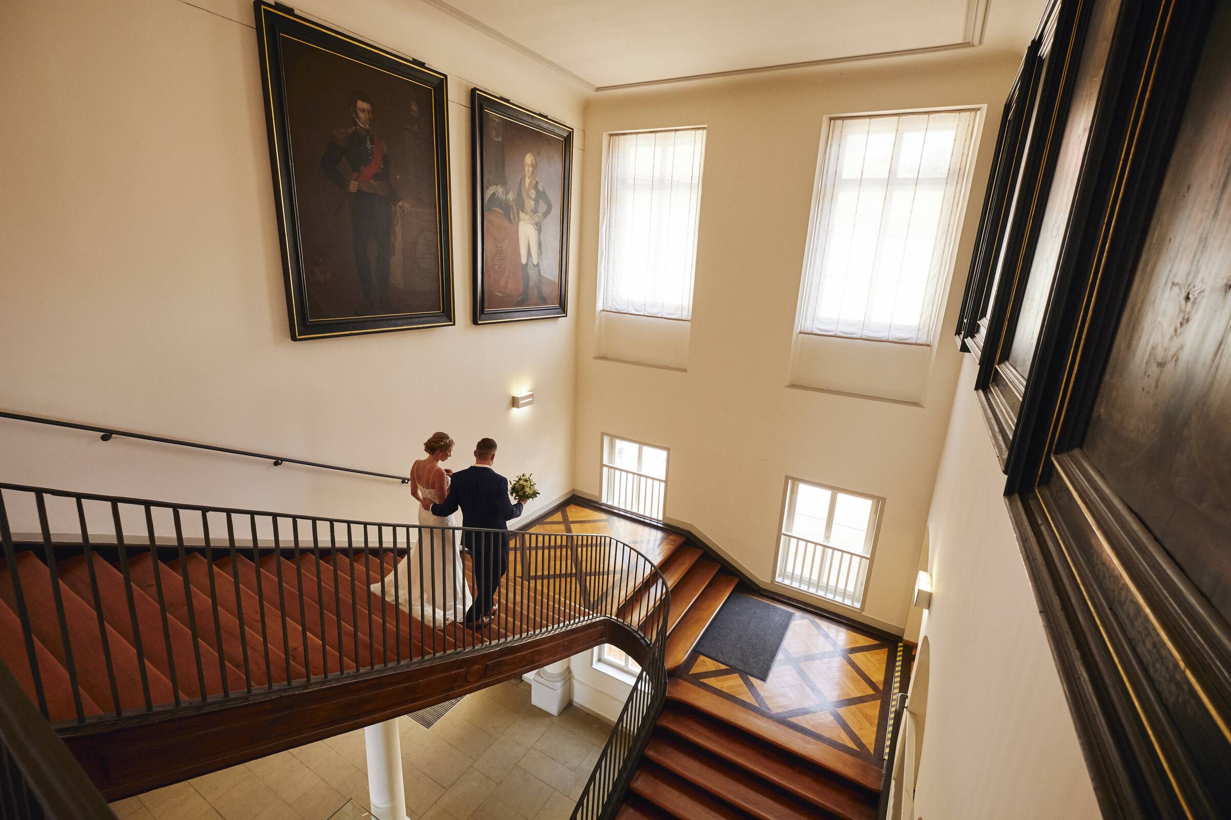 Brautpaar auf der Holztreppe eines historischen Hauses, Blick von oben