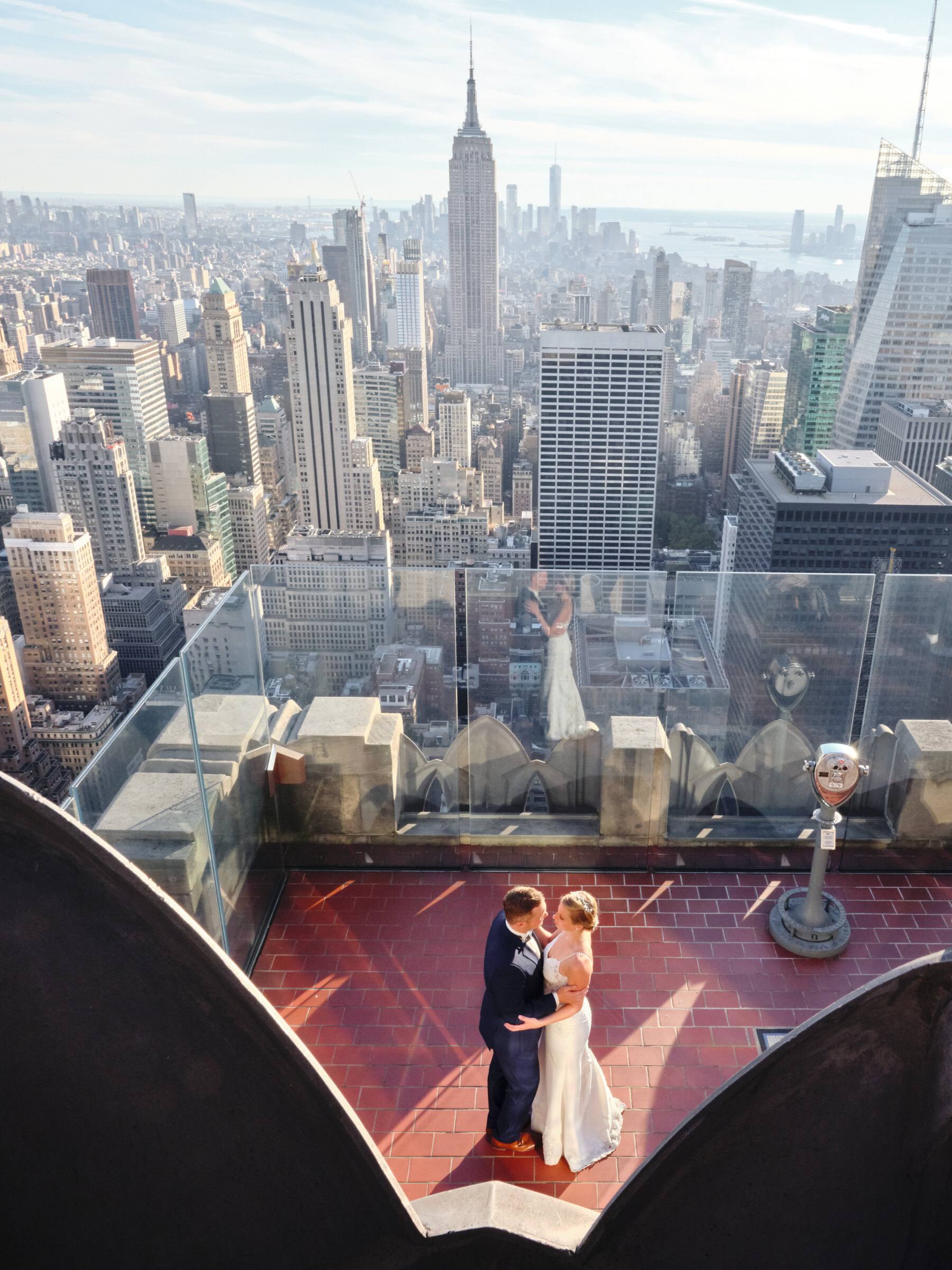 Brautpaar umarmt sich auf der Aussichtsplattform, Blick auf die Hochhäuser von Manhattan
