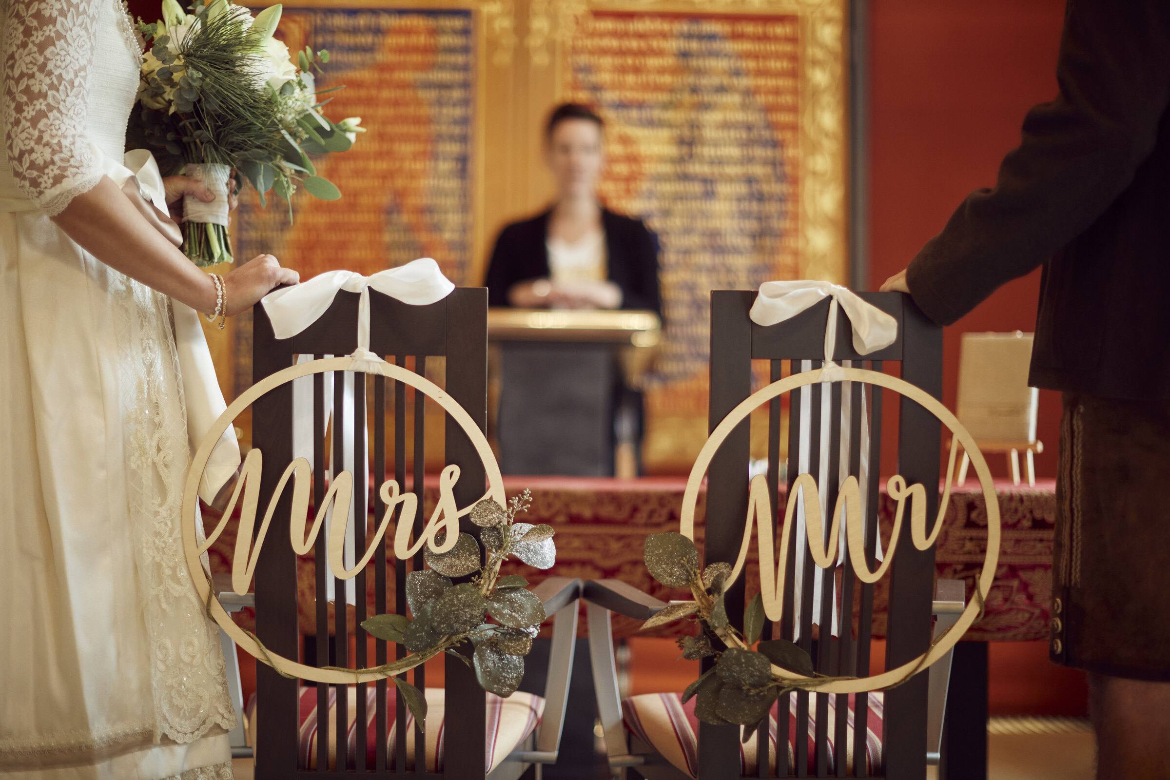 Zwei Stühle mit Holzkreisen „Mrs“ und „Mr“ im historischen Trauzimmer