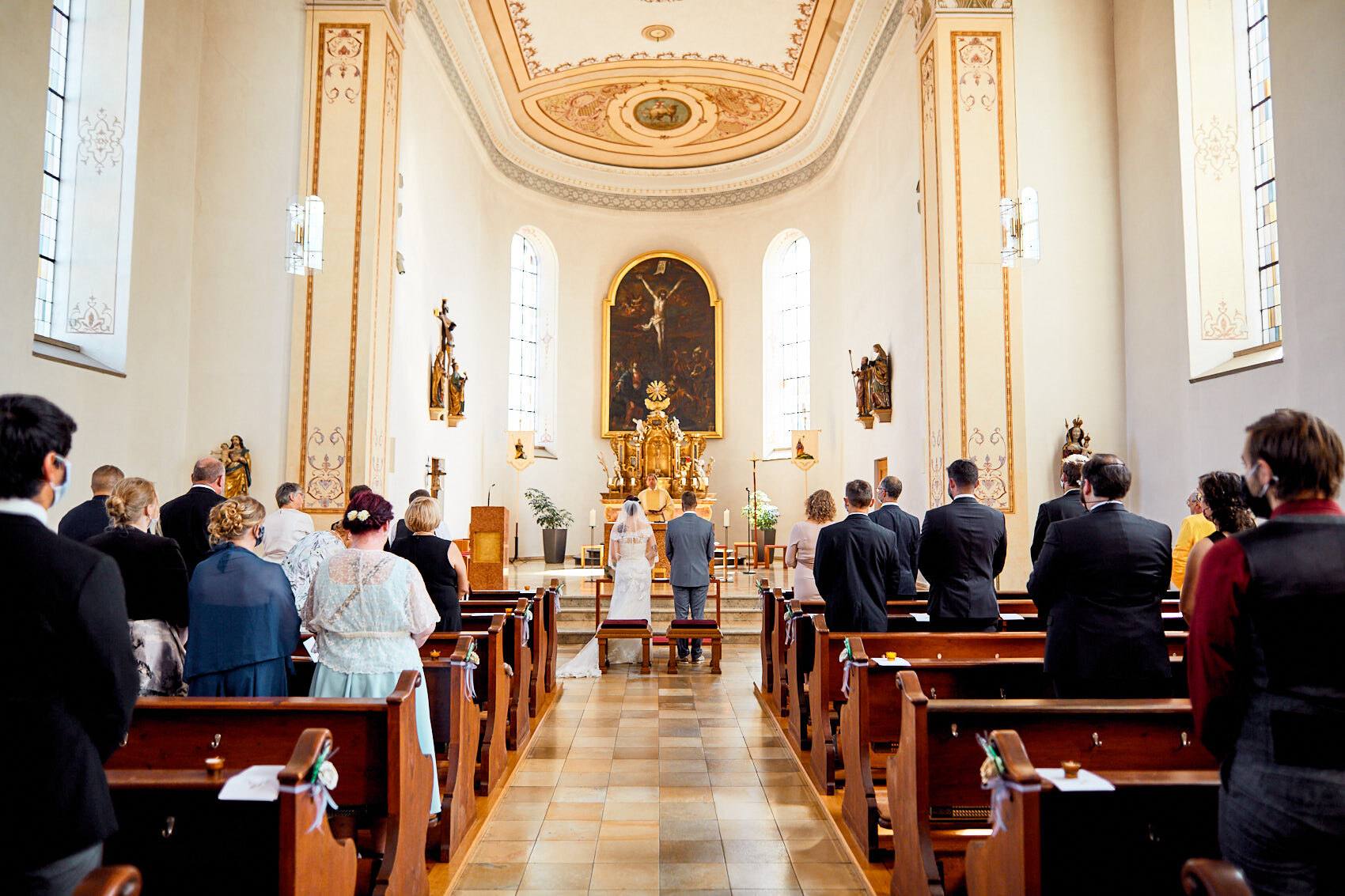 Blick durch die barocke Kirche mit goldenem Stuck während der Trauung