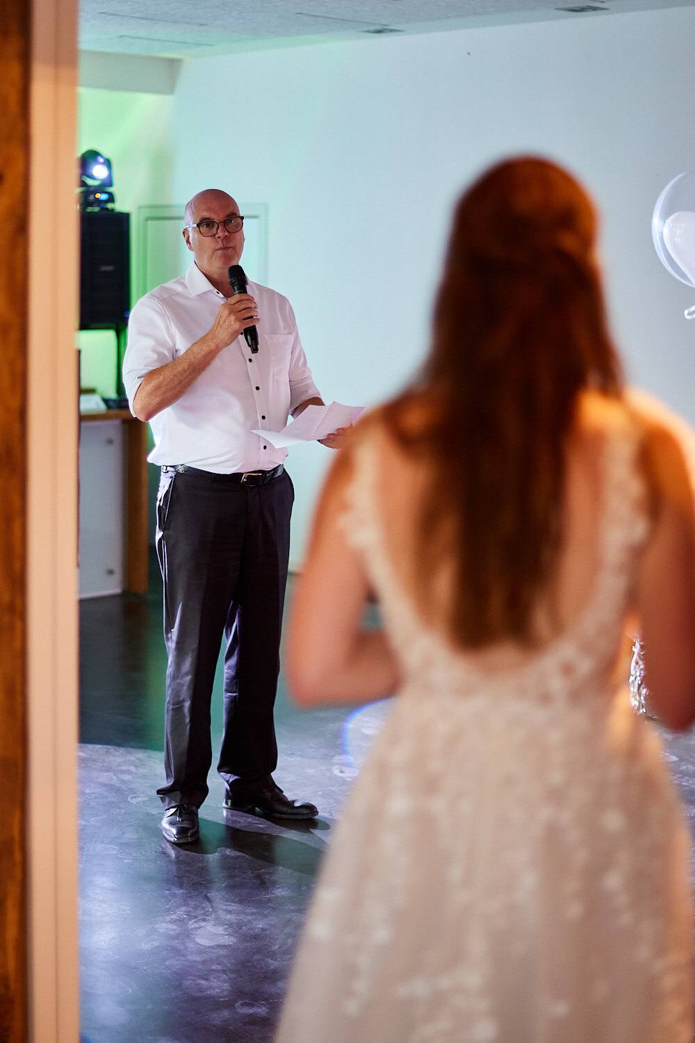 Vater hält eine Rede, Braut von hinten.