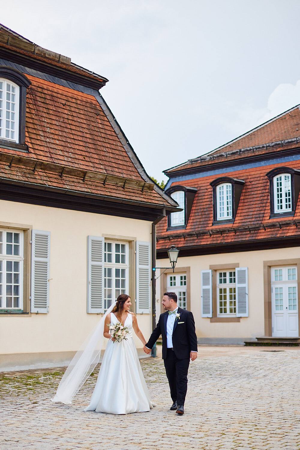 Brautpaar im Schlosshof zwischen den roten Dächern